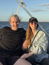 A happy couple enjoys a moment together on a boat, capturing the joy of their outing against a scenic backdrop.