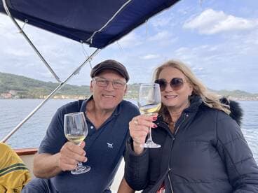 A couple raises their glasses in a toast while enjoying a scenic boat ride, perfect for romantic getaways or special celebrations on the water.