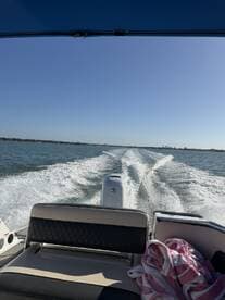 Interior view of a boat's seating area, showcasing the helm and a towel, perfect for a day on the water.