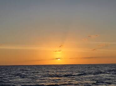 A stunning sunset over the ocean, creating a picturesque backdrop for evening boat cruises.