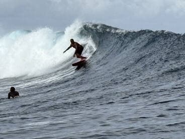 A surfer skillfully rides a wave in the ocean, showcasing the thrill of water sports and adventure on the water.