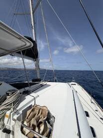 A clear view of the deck of a sailboat, showcasing its sleek design and the open sea ahead, perfect for sailing enthusiasts.