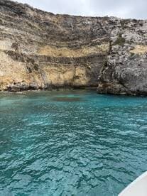 A stunning view of a rocky coastline with turquoise waters, perfect for exploring the natural beauty of the area by boat.