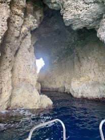 A stunning view of a natural cave formation with sunlight streaming through, showcasing the beauty of coastal scenery — perfect for adventure seekers exploring hidden gems.