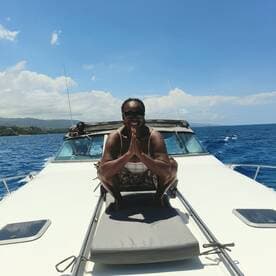 A joyful moment on a boat with a smiling guest striking a playful pose against the backdrop of the ocean — perfect for capturing fun experiences on the water.