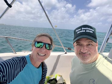 A cheerful couple enjoys a sunny day on the boat, capturing a fun selfie with the beautiful ocean in the background — perfect for memorable adventures on the water.