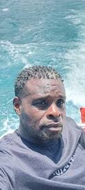 A man enjoys a sunny day on the water, capturing the moment while cruising on a boat. Perfect for showcasing the joy of boating adventures.