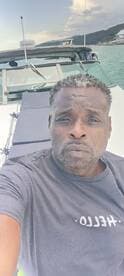 A man poses for a selfie on a boat, showcasing the beautiful surroundings — perfect for capturing memorable moments on the water.