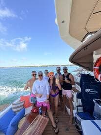 A lively group enjoys a celebration aboard a yacht, raising their drinks against a backdrop of sparkling waters and clear skies — perfect for unforgettable moments on the water.