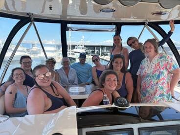 A cheerful group of friends gathers inside a boat, enjoying their time together — perfect for celebrations and memorable outings on the water.