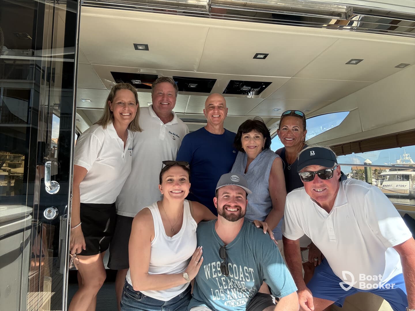 A cheerful group poses together inside a luxurious boat, capturing a moment of celebration and camaraderie on the water.