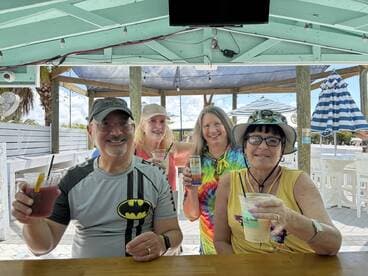 A cheerful group enjoys cocktails at a vibrant bar, capturing the essence of a fun day out on the water with friends.