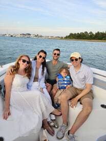 A joyful family poses together on a boat, enjoying a beautiful day on the water — perfect for memorable outings and celebrations.