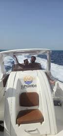 A couple enjoys a thrilling boat tour on a sunny day, capturing the excitement of their adventure aboard the Sunghada speedboat.
