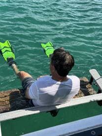 A man prepares to snorkel in clear turquoise waters, showcasing the excitement of on-water activities and adventure.