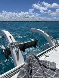 A close-up view of a catamaran's deck with the turquoise waters in the background, showcasing the vessel's structure and the serene boating experience.