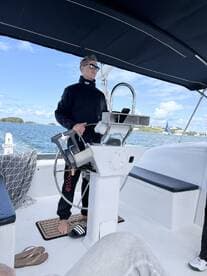 A captain navigates from the helm of a sleek sailboat, showcasing the modern interior and steering console, perfect for a day on the water.