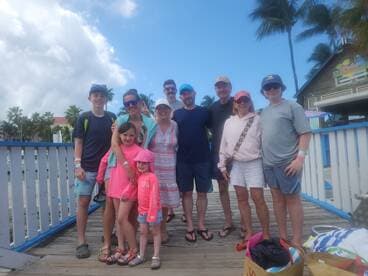 A joyful family poses together on a dock, capturing a memorable moment during their tropical adventure — perfect for family vacations and group trips.