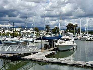 A beautiful yacht docked at a marina, surrounded by other boats and a scenic waterfront view, perfect for boating enthusiasts.