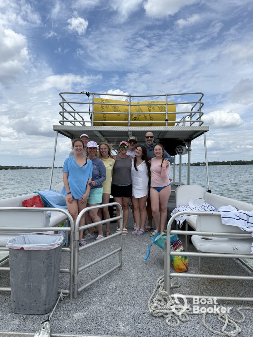 A cheerful group poses together on a pontoon boat, capturing a memorable moment on the water — perfect for celebrations and fun outings.