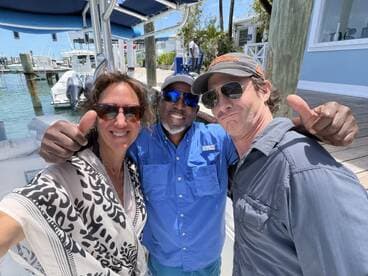 A cheerful group poses for a selfie with thumbs up, capturing a fun moment at the marina — perfect for celebrating a day on the water.