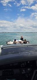 A group enjoys a sunny day on the boat, relaxing and sunbathing while taking in the beautiful waterscape — perfect for a fun day out on the water.
