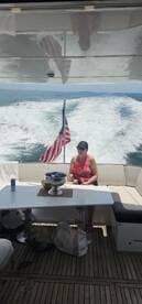A woman relaxes in the interior of a boat, enjoying the view as it cruises through the water. The setting is perfect for a leisurely day on the water.
