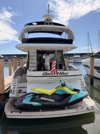 A luxurious Galeon yacht docked at Marco Island, featuring a vibrant Sea-Doo jet ski on the deck, perfect for water adventures.