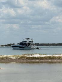 A scenic view of a boat with a jet ski in action nearby, showcasing the fun and adventure of water activities.