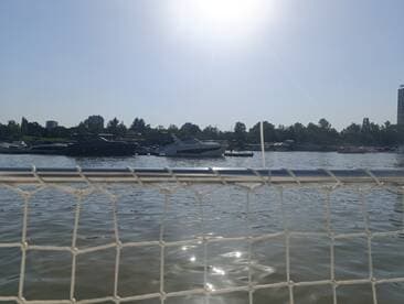 A scenic view of various yachts docked along the waterfront, showcasing a vibrant marina atmosphere under a clear sky.