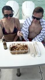 Two guests enjoy a delicious spread of snacks on board, perfect for a day out on the water.