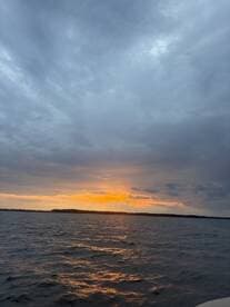 A serene sunset over calm waters, showcasing the beauty of nature — perfect for peaceful evening boat rides.