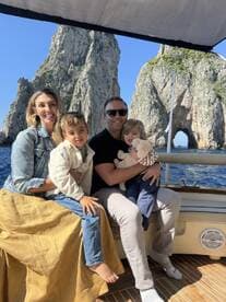A joyful family enjoys a boat trip with stunning rock formations in the background, creating unforgettable memories on the water.
