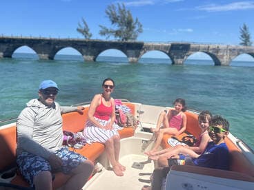 A joyful family enjoys a sunny day on a boat, relaxing and having fun together — perfect for creating lasting memories on the water.