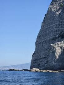 A stunning view of a rugged coastline with towering cliffs, showcasing the natural beauty of the area — perfect for scenic boat tours.