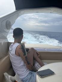 A relaxed moment inside a boat cabin, showcasing a guest enjoying the view while seated comfortably. Perfect for highlighting the interior ambiance of a luxury vessel.