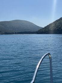 A serene view of mountains reflecting on calm waters, showcasing the beauty of nature during a boating trip.