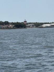 A distant view of a lighthouse and waterfront buildings, but the image is unclear and lacks detail.