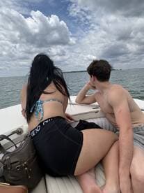 A couple enjoys a scenic view from the boat, surrounded by calm waters and dramatic clouds — perfect for a relaxing day on the water.