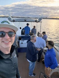 A lively group enjoys a boat party at sunset, capturing moments of camaraderie and celebration on the water.