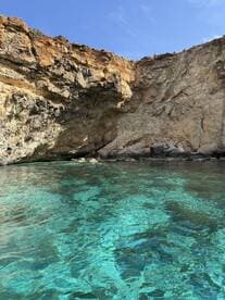 A stunning view of a rocky coastline with crystal-clear waters, perfect for exploring hidden coves and enjoying the beauty of nature.