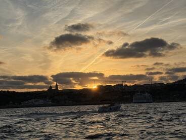 A stunning sunset over the harbor, with silhouettes of boats and buildings creating a picturesque backdrop — perfect for evening cruises and scenic views.