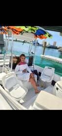 A woman relaxes in the interior of a boat, showcasing comfortable seating and a vibrant atmosphere, perfect for a day on the water.