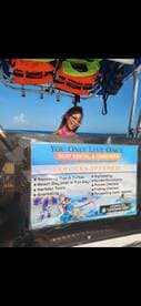 A smiling woman on a boat showcases various services offered, including snorkeling and private charters, perfect for adventure seekers looking to explore the waters.