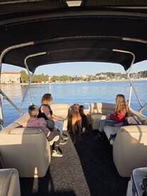A group enjoys a relaxing day on a boat, accompanied by their dogs, showcasing a perfect blend of family fun and pet-friendly adventures on the water.
