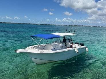 A fishing boat navigates through crystal-clear waters, showcasing an exciting day on the water with anglers ready for their catch.