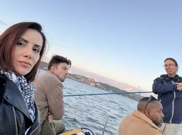 A group of friends enjoys a relaxed moment on a boat, engaging in conversation while taking in the scenic views — perfect for social outings on the water.
