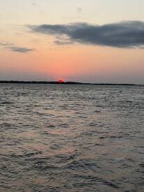 A stunning sunset over the water, casting vibrant colors across the sky and reflecting on the waves — a perfect moment for relaxation and appreciation of nature.