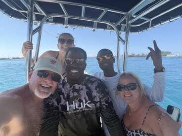 A cheerful group of friends poses for a selfie on a boat, enjoying their time on the water — perfect for capturing memorable moments during a fun day out.