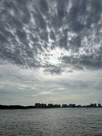 A cloudy sky over a waterfront view, with buildings visible in the distance. The image lacks clarity and focus.